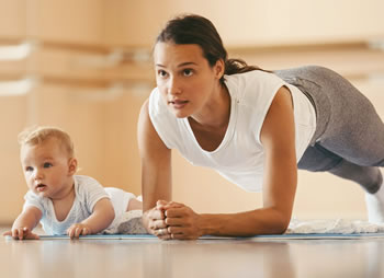 Una mamma che si allena col suo neonato